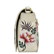 Load image into Gallery viewer, Side view of a beige leather Flap Crossbody - 683 handbag by Anuschka with a floral design.
