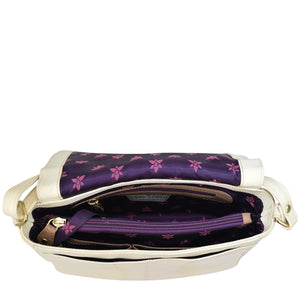 Open Anuschka Flap Crossbody - 683 revealing a purple floral interior with compartments and a crossbody strap.