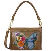 Anuschka Shoulder Organizer - 684 in brown genuine leather, featuring a colorful butterfly and floral design on the front zippered pocket, complete with RFID protection and a removable crossbody strap.