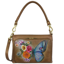 Load image into Gallery viewer, Anuschka Shoulder Organizer - 684 in brown genuine leather, featuring a colorful butterfly and floral design on the front zippered pocket, complete with RFID protection and a removable crossbody strap.
