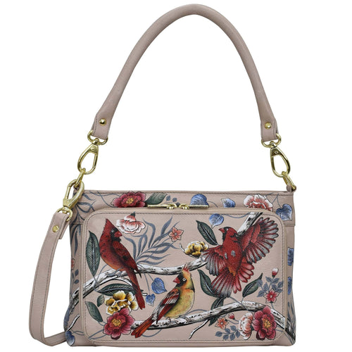 A beige leather shoulder bag with a floral and bird print design, gold-colored hardware, and RFID protection - Anuschka's Large RFID Organizer - 684.