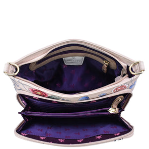 An open, empty Anuschka leather handbag displaying its inner compartments, Large RFID Organizer - 684 features, and floral lining.