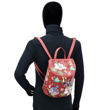 Load image into Gallery viewer, A mannequin wearing a black outfit and showcasing a colorful floral Anuschka Bucket Backpack - 685 with adjustable straps.
