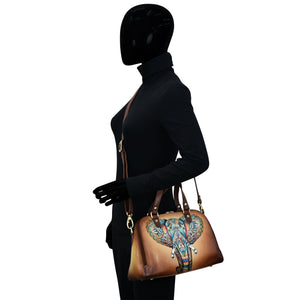 Mannequin with black attire and Anuschka Wide Organizer Satchel - 695 featuring hand painted elephant design.
