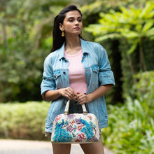 Load image into Gallery viewer, Woman holding a Anuschka Wide Organizer Satchel - 695 wearing a denim jacket outdoors.
