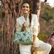 Load image into Gallery viewer, Woman in a white suit posing outdoors with an Anuschka Wide Organizer Satchel - 695.
