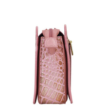 Load image into Gallery viewer, Side view of a pink crocodile texture Anuschka Triple Compartment Crossbody - 696 handbag with gold zipper detail and organized compartments.
