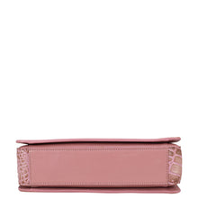 Load image into Gallery viewer, Side view of a pink, organized Triple Compartment Crossbody - 696 by Anuschka with a textured design and compartments.

