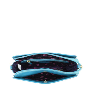 A teal-colored Anuschka Triple Compartment Crossbody - 696 pouch with a floral pattern interior, ideal for organized travel, isolated on a white background.