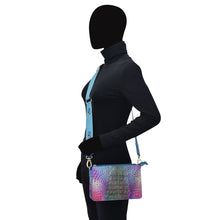 Load image into Gallery viewer, Person wearing a black outfit and a multicolored Anuschka Triple Compartment Crossbody - 696 bag, standing side-on with a silhouette for a head.

