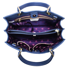 Load image into Gallery viewer, Top view of an open blue Anuschka Medium Satchel - 697 showcasing its Italian-inspired interior compartments and purple lining with floral pattern.
