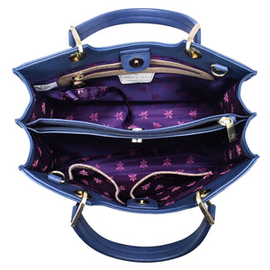 Top view of an open blue Anuschka Medium Satchel - 697 showcasing its Italian-inspired interior compartments and purple lining with floral pattern.