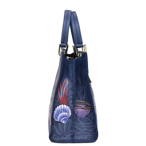 Side view of a chic blue Anuschka Medium Satchel - 697 with floral embossing and gold-tone hardware.