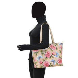 Mannequin displaying a hand-painted Anuschka Large Zip Top Tote - 698 with a zippered pocket.