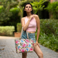 Load image into Gallery viewer, A woman posing outdoors with a Anuschka Large Zip Top Tote - 698, hand-painted with florals.
