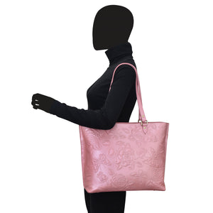 A mannequin showcasing a pink "Large Zip Top Tote - 698" from Anuschka with floral hand-painted artwork.