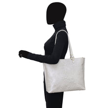 Load image into Gallery viewer, A person with a black silhouette profile carrying a Anuschka Large Zip Top Tote - 698 on their shoulder.
