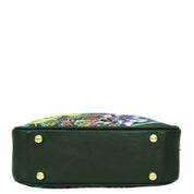 A green leather Twin Top Messenger - 704 with a floral design by Anuschka is shown from the bottom, displaying four gold studs at the base and a removable adjustable strap.