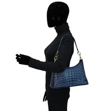 Load image into Gallery viewer, Mannequin with featureless head wearing a black long-sleeved turtleneck, gloves, and carrying a blue textured Anuschka Hobo With Chain Strap - 707 handbag.
