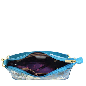 Open Anuschka genuine leather designer handbag showing interior compartments and zipper closure.