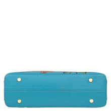 Load image into Gallery viewer, A blue Anuschka genuine leather wallet with gold-tone stud details and a floral interior peeking out from inside.
