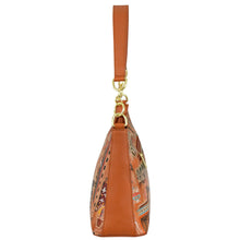 Load image into Gallery viewer, Side view of the Anuschka Zip-Top Shoulder Hobo - 707, an orange handbag featuring a top handle, gold hardware, a chain detail shoulder strap, and an intricate multicolored patterned design.
