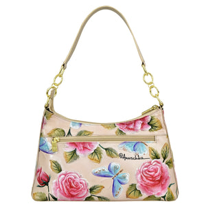 An Anuschka Hobo With Chain Strap - 707 featuring a floral pattern, rose motifs, and a dragonfly illustration.