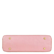 Pink Anuschka genuine leather clutch with gold-tone studs on a white background.