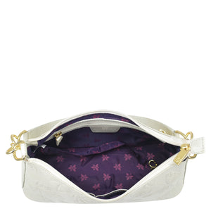 White genuine leather Anuschka Hobo With Chain Strap - 707 purse with open zipper revealing a purple floral-patterned interior and chain detail shoulder strap.