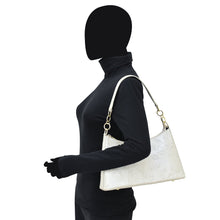 Load image into Gallery viewer, Woman in black attire carrying a white leather Anuschka Hobo With Chain Strap - 707.
