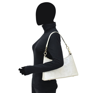 Woman in black attire carrying a white leather Anuschka Hobo With Chain Strap - 707.