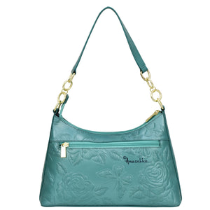 Teal leather Anuschka hobo bag with floral embossing and gold-tone hardware, featuring a chain detail shoulder strap.