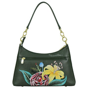 The Anuschka Zip-Top Shoulder Hobo - 707 is a dark green leather bag adorned with a floral painting, showcasing a yellow lily and a red flower. It features a gold zipper and hardware, complemented by a chain detail shoulder strap.