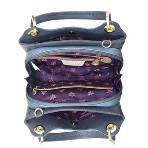 Top view of an open, empty Anuschka blue leather satchel with Crossbody Strap - 708 displaying multiple compartments with a purple floral lining.