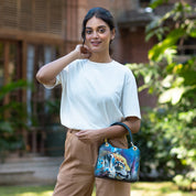 Woman posing with an Anuschka satchel with crossbody strap outdoors.