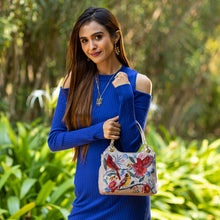 Load image into Gallery viewer, Woman posing with an Anuschka Satchel With Crossbody Strap - 708 in a garden setting.
