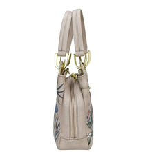 Load image into Gallery viewer, Beige leather Anuschka satchel with floral design and gold-tone hardware.
