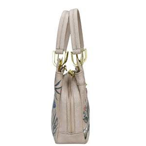 Beige leather Anuschka satchel with floral design and gold-tone hardware.