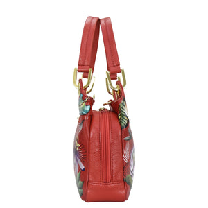 Anuschka's Satchel With Crossbody Strap - 708, features a red leather design with tropical bird and leaf print and gold-tone hardware.