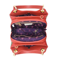 Load image into Gallery viewer, Top view of an open red leather Anuschka satchel with a purple floral interior lining.
