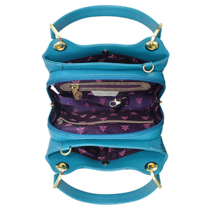 Three stacked Anuschka blue leather handbags with zippers open to reveal a purple floral interior.
