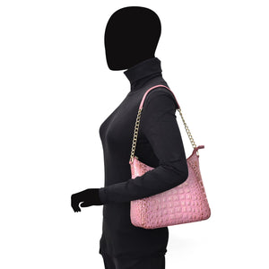 A mannequin dressed in black with a pink, genuine leather Zip-Top Shoulder Hobo - 709 from Anuschka showcasing chain link detail.