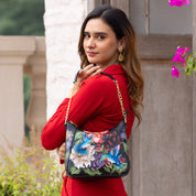 A woman in a red outfit with an Anuschka Zip-Top Shoulder Hobo - 709 over her shoulder, looking over her shoulder at the camera.