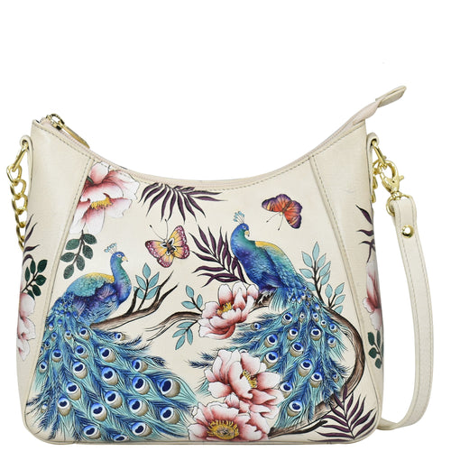Cream-colored Anuschka Zip-Top Shoulder Hobo - 709 with floral and peacock print design and chain link detail.