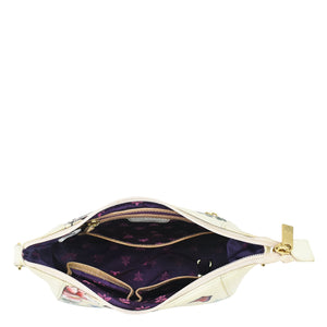 Open white Anuschka Zip-Top Shoulder Hobo - 709 with floral pattern and purple interior.