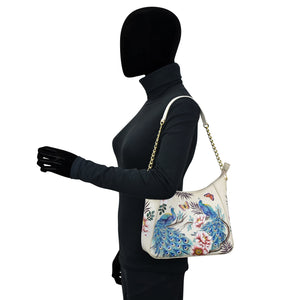 Mannequin displaying an Anuschka Zip-Top Shoulder Hobo - 709 with a floral design and a chain strap.