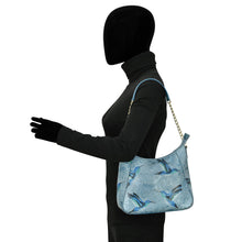 Load image into Gallery viewer, Mannequin displaying a blue patterned Anuschka Zip-Top Shoulder Hobo - 709 with a chain link detail strap.
