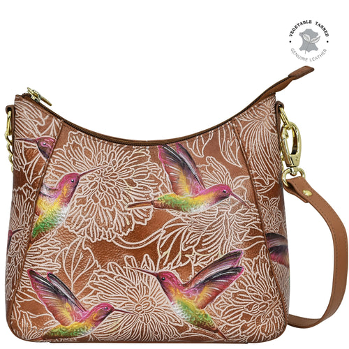 An Anuschka Zip-Top Shoulder Hobo - 709, a genuine leather purse with a floral and hummingbird print design, featuring hand-painted artwork.