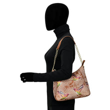 Load image into Gallery viewer, Side profile of a mannequin dressed in black and carrying an Anuschka Zip-Top Shoulder Hobo - 709 with hand-painted artwork.
