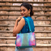 Woman posing with a colorful Anuschka Medium Everyday Tote - 710 over her shoulder, looking back over her shoulder on a stairway.